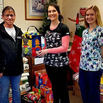 Laura and Tori giving their donations to Deb