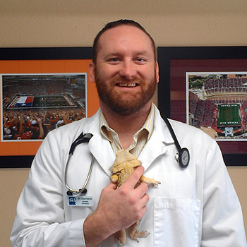 Dr. Chad Harris posing with a reptilian friend